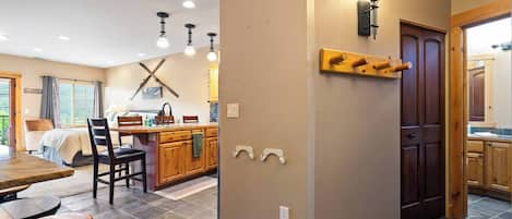 Una cocina amplia con armarios de madera, un comedor con mesa y sillas, y un ventanal con cortinas.