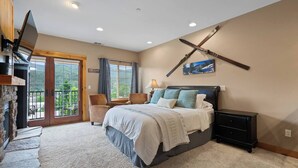 A bedroom with a bed, a TV, a desk, and a chair. - Alpine Suite, Sauna, Pool Table & DT Kellogg (Kellogg)