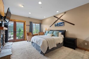 Ein Schlafzimmer mit Bett, Fernseher, Schreibtisch und Stuhl.