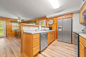 Eine moderne Küche mit Holzschränken, Edelstahlgeräten und einer zentralen Kochinsel.