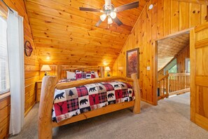A wooden cabin bedroom with a bed, two bedside lamps, a ceiling fan, and a window with blinds. - Marvelous 2-bedroom cabin located behind Dollywood. (Sevierville)