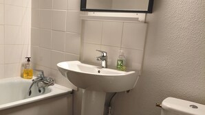 Ein Badezimmer mit einer Badewanne, einem Waschbecken und einer Toilette.