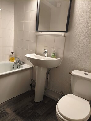 A bathroom with a bathtub, sink, and toilet. - Wellness and Relaxation Studio (La Tour-du-Pin)