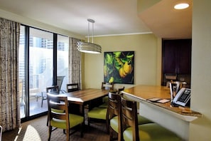 A hotel room with a dining area, a painting, a telephone, and a view of the city. - Oceanfront View in Honolulu at The Hilton Hawaiian Village Lagoon Tower (Honolulu)