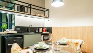 A compact kitchen with a dishwasher, microwave, and a dining area with a table set for two.