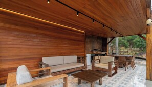A wooden interior with a sofa, chairs, and a dining table.