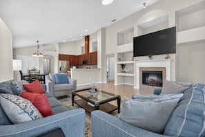 A spacious living room with a large sofa, a coffee table, and a fireplace.