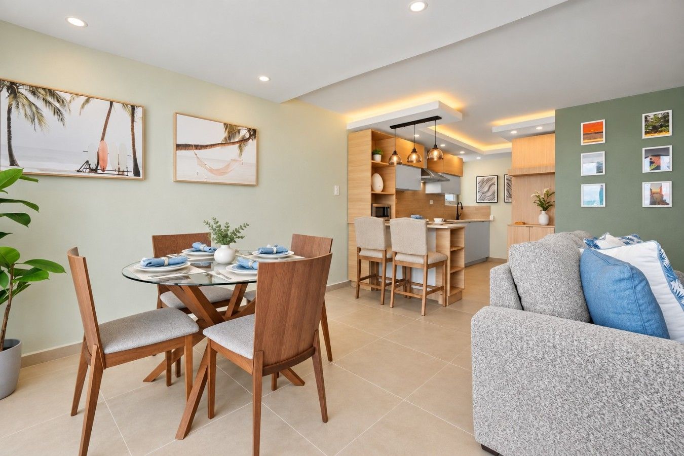 A modern living room with a dining area, kitchen, and a sofa.