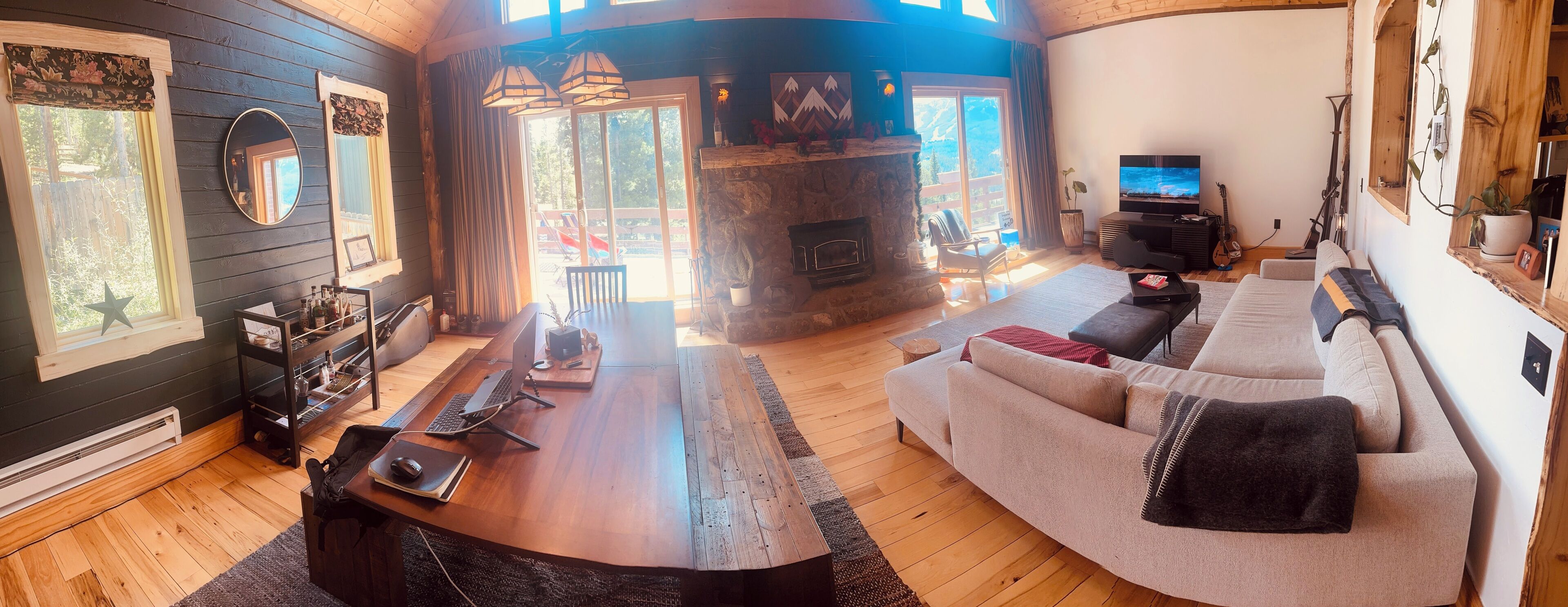 A cozy living room with a fireplace, a sofa, a dining table, and a TV.