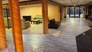 A lobby area with seating, a reception desk, and a door leading outside. - HILLTOP INN (Barre)
