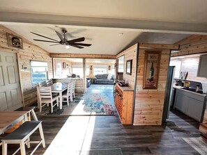 A spacious room with a dining area, a kitchen, and a living space.