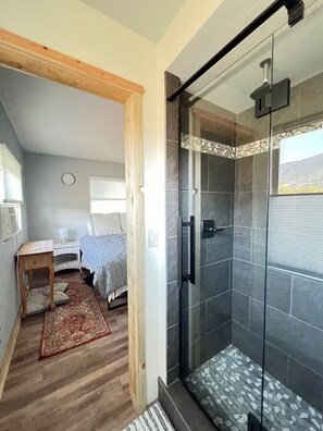 Une chambre à coucher avec un lit, une table de chevet et un petit bureau.