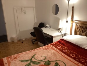A room with a bed, a desk with a chair, a lamp, a trash bin, and a wall-mounted towel rack. - Two bed room suite, ground floor, south facing down town city and garden view, (West Vancouver)