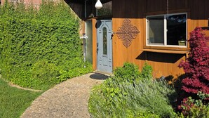 Una casa de madera con puerta azul y un adorno en la pared.