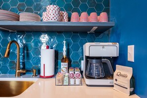 Eine Küchenarbeitsplatte mit Kaffeemaschine, einer Spirituosenflasche und einer Kaffeetüte.