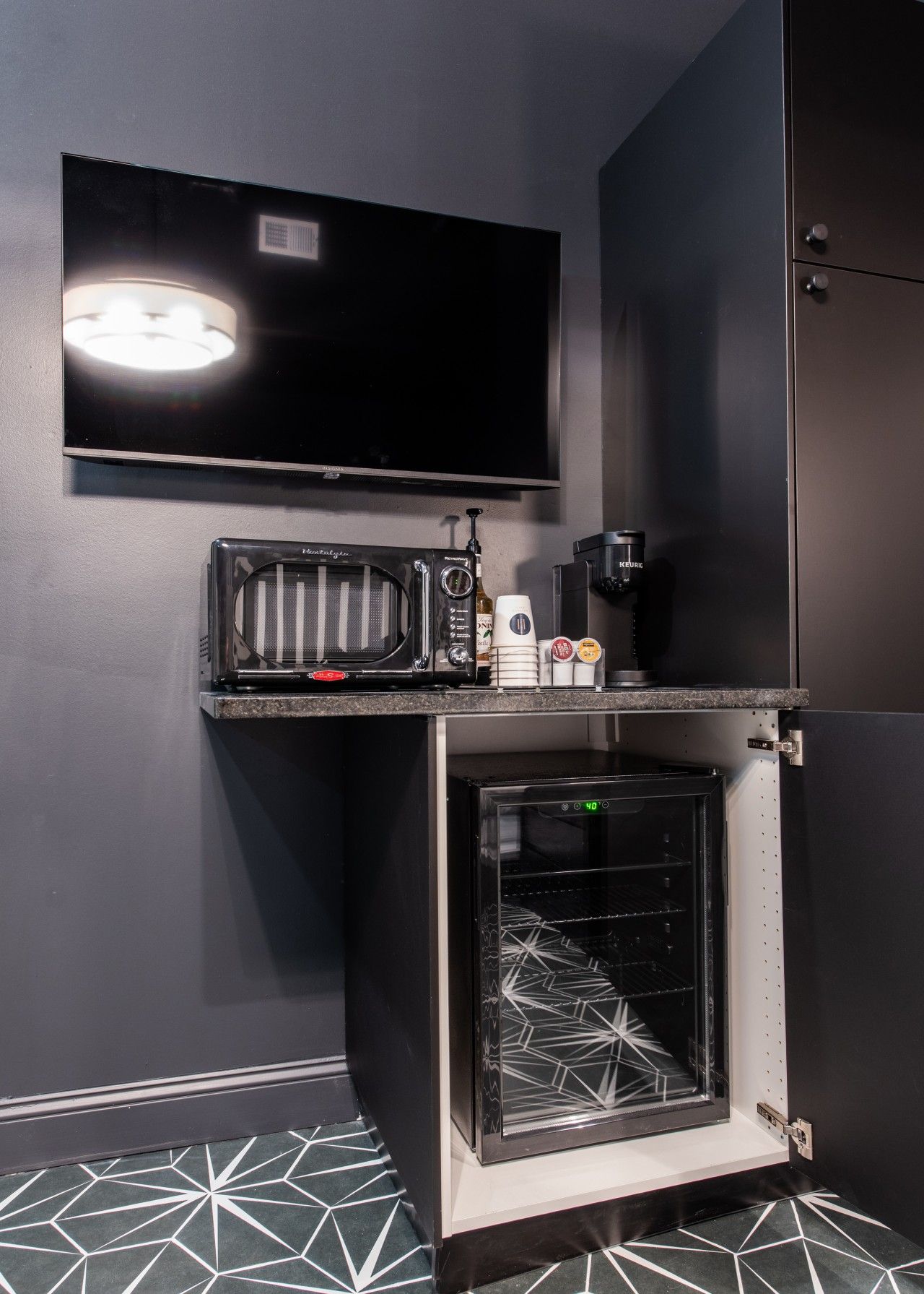 Une petite cuisine équipée d’un four à micro-ondes, d’une machine à café et d’un four.