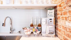 Eine Küchenzeile mit Kaffeemaschine, Kaffeepackung und einer Schüssel mit Snacks.