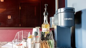 Eine Kaffeemaschine, eine Flasche Monin-Sirup und eine Vorratsdose mit verschiedenen Gewürzen auf einer Küchenarbeitsplatte.