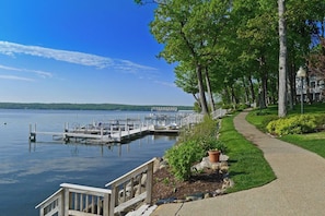 A waterfront property with a dock, a walking path, and a view of the lake. - Walk to Lake & Restaurants | Fire Table, Ping Pong, Shuffleboard | Sleeps 12 (Williams Bay)