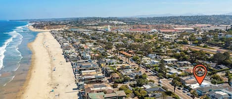 Eine Küstenstadt mit Strand, Wohnhäusern und einem markanten Riesenrad.