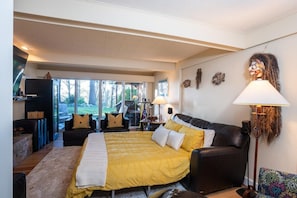 A modern bedroom with a large bed, a sofa, and a floor lamp.