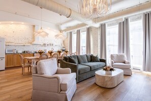 A modern living room with a sofa, armchairs, and a coffee table. - Hollyhock Suite 301: 4 Bed/2 Bath (Louisville)