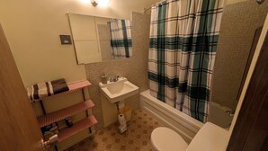 Une salle de bain comprenant des toilettes, un lavabo et un espace douche.