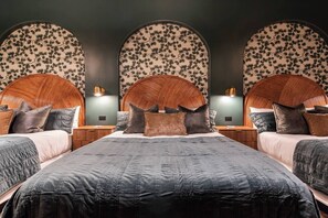 Ein Hotelzimmer mit einem großen Bett, zwei Nachttischen und einer Wand mit einem Blumenmuster.