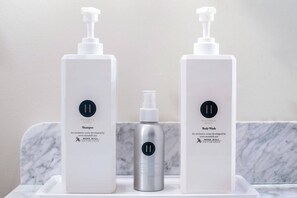 Zwei weiße Flaschen mit Dosierern auf einer Marmorfläche, eine mit der Aufschrift 'Shampoo' und die andere 'Body Wash', beide von Moss Hill.