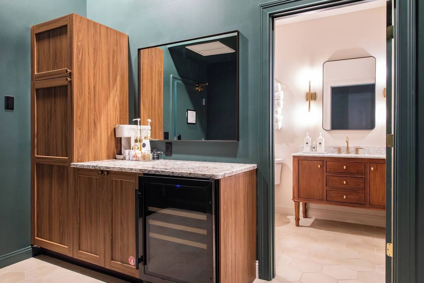 A modern bathroom with a wooden vanity, a glass shower enclosure, and a separate sink area.