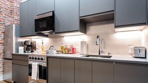 Una cucina moderna con elettrodomestici in acciaio inossidabile, forno integrato e microonde.