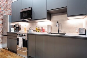 Eine moderne Küche mit Edelstahlgeräten, einem Backofen und einer Mikrowelle.