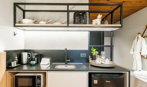 A compact kitchen with a built-in coffee maker, a microwave, and a dishwasher.