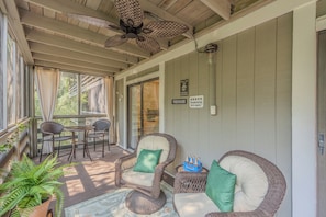 A covered outdoor seating area with wicker furniture, a ceiling fan, and a view of the outdoors. - Amelia Island Condo - secret walking trail to the beach! (Fernandina)