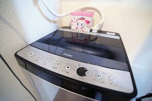 Ein Haier-Gerät mit Bedienfeld, Netzkabel und einer Schachtel mit japanischen Schriftzeichen.