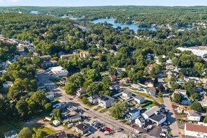 An aerial view of a residential area with houses, roads, and a lake.