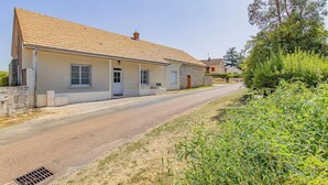 A two-story house with a tiled roof, a front porch, and a driveway.