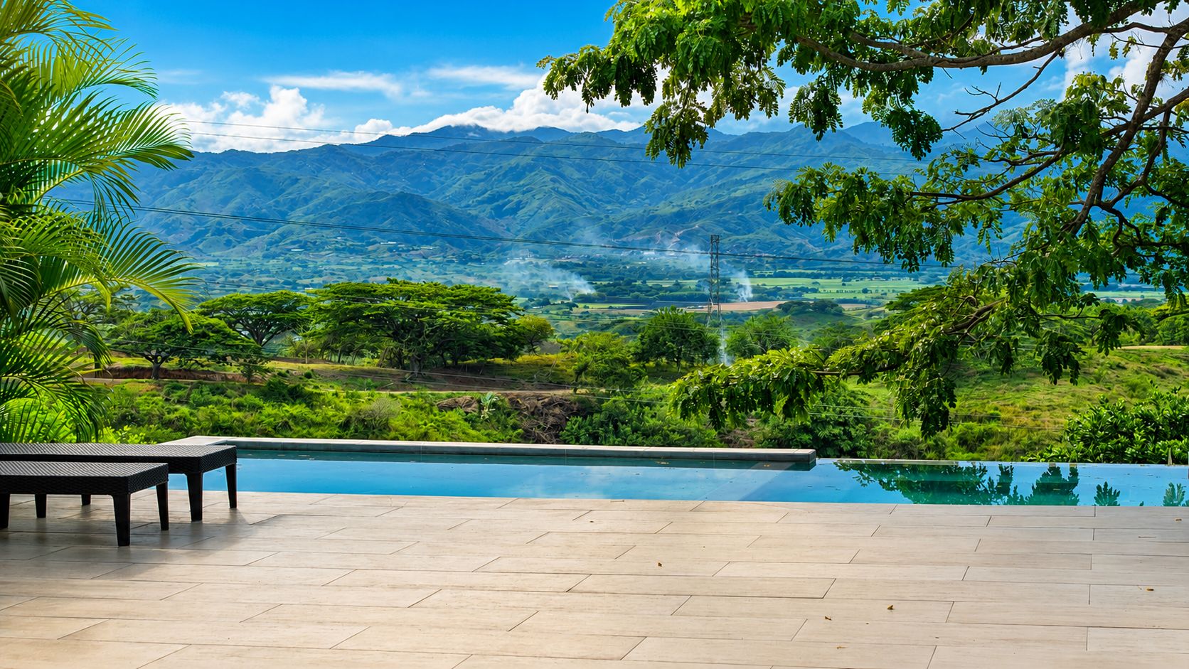 A pool area with a view of mountains and greenery.