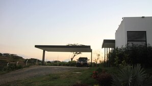 A modern building with a covered driveway and a parked vehicle. - LoftMerak sunsets, Jacuzzi, terrace, privacy, wifi (Pereria)