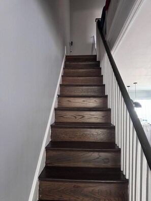 A staircase with wooden steps and white railings. - 3-bedroom house in tranquil Philadelphia with cool Central Air (Philadelphia)