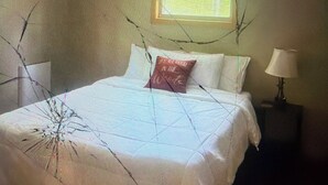 A bedroom with a bed, a window, and a nightstand with a lamp. - Cabin 38 miles from Beach Mountain ski resort 5 miles from the lake in winery (Butler)