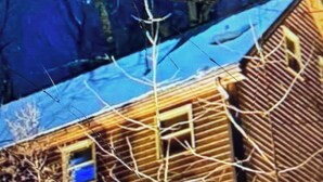 A building with multiple windows and a visible door, surrounded by bare trees. - Cabin 38 miles from Beach Mountain ski resort 5 miles from the lake in winery (Butler)