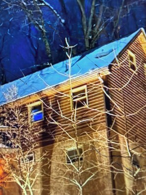 A building with multiple windows and a visible door, surrounded by bare trees. - Cabin 38 miles from Beach Mountain ski resort 5 miles from the lake in winery (Butler)