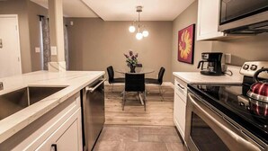 A compact kitchen with a dining area, a coffee maker, and a kettle. - Carlton Suite 1b/1b near UNLV (Las Vegas)