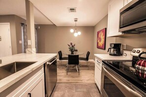 A compact kitchen with a dining area, a coffee maker, and a kettle. - Carlton Suite 1b/1b near UNLV (Las Vegas)