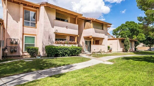 A multi-story residential building with a flat roof, balconies, and a well-maintained lawn. - Carlton Suite 1b/1b near UNLV (Las Vegas)