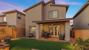 A modern two-story residential building with a patio area, outdoor seating, and a well-maintained lawn. - Skye Canyon 3 bedrooms + Loft (Las Vegas)