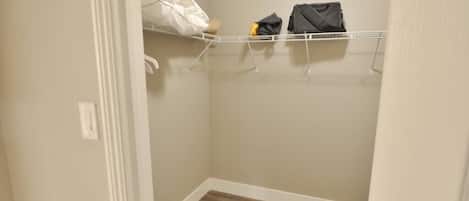 Un armario con piso de madera y puerta blanca.