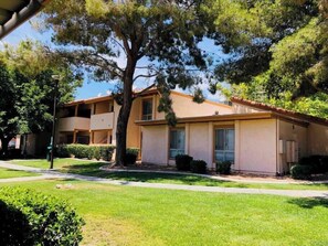 A two-story building with a flat roof, a central entrance, and a small front yard with a tree. - Crawford suite 1b/1b near UNLV (Las Vegas)
