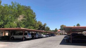 A parking area with covered carports and multiple vehicles parked. - Nova Suite 1b/1b close to strip! (Las Vegas)